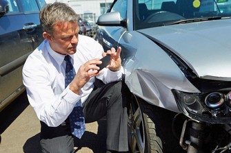 Collision Auto Body Estimator Taking Photos of Front Fender Auto Body Damage