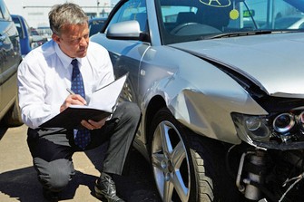 Collision Auto Body Estimator Inspecting Front Fender Auto Body Damage